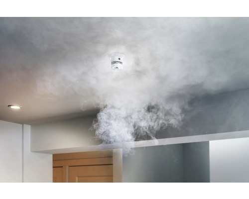 Rookmelder aan het plafond met rook in de kamer