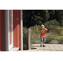 Jongen met waterpistool naast een tuinkraan