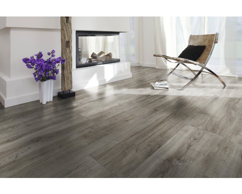 Lichte woonkamer met laminaatvloer in houtlook, open haard en fauteuil