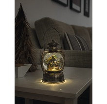 Decoratieve lantaarn met sneeuwbol en kerststal op een tafel