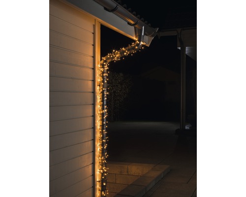 Verlichte dakgoot met lichtsnoer aan het huis.