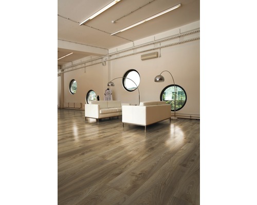 Lichte ruimte met houten vloer, banken en ronde ramen.