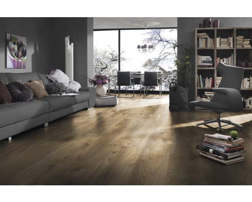 Woonkamer met laminaatvloer, bank, boekenkast en raam met winterlandschap