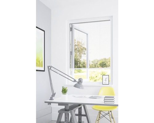 Lichte studeerkamer met jaloezieën voor het raam, bureau en bureaulamp