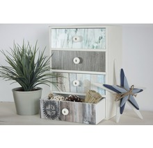 Ladekast met vier laden in houtlook naast sierplant en decoratieve ster
