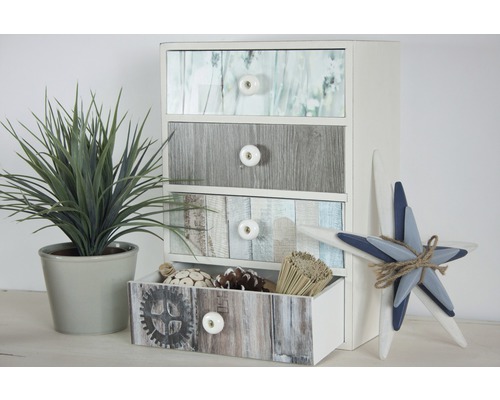 Ladekast met vier laden in houtlook naast sierplant en decoratieve ster