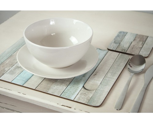 Gedekte tafel met witte kom, bord, bestek en onderzetters in houten design