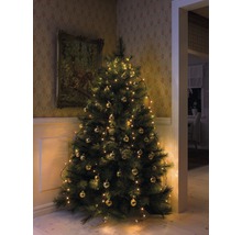 Versierde kerstboom met ballen en lichtjes in een hoek van de kamer