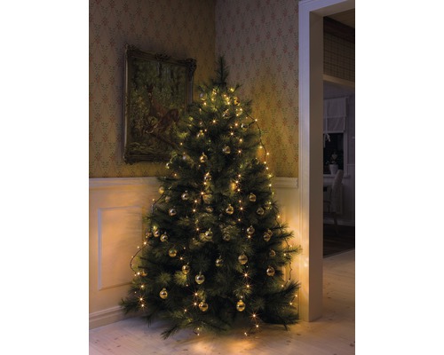 Versierde kerstboom met ballen en lichtjes in een hoek van de kamer