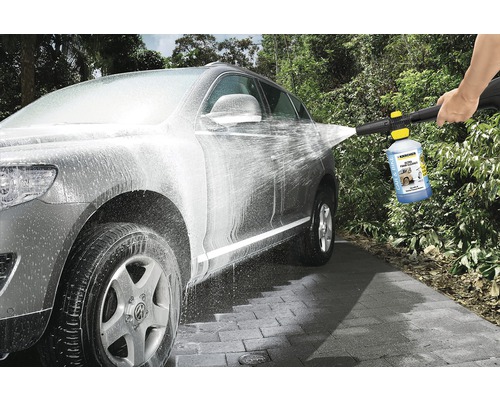 Een auto wordt schoongemaakt met een hogedrukreiniger en autoshampoo.