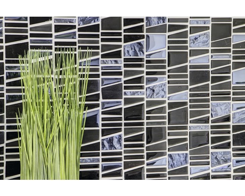 Mozaïektegels in zwart en grijs met een groene decoratie.