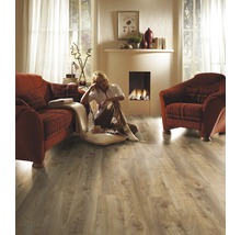 Woonkamer met laminaatvloer, bank, fauteuil en open haard