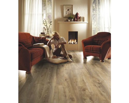 Woonkamer met laminaatvloer, bank, fauteuil en open haard