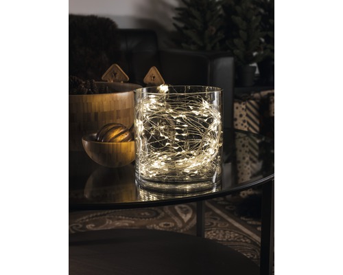 Decoratieve lichtslinger in een glazen pot op een tafel