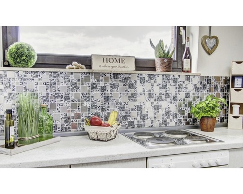 Detailopname van een moderne keuken met mozaïektegels als spatwand, kookplaat en diverse decoraties.