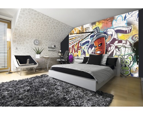 Slaapkamer met graffiti behang, bed en vloerkleed