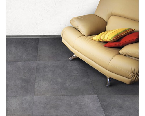 Woonkamer met lichtbruine leren bank en grijze tegelvloer
