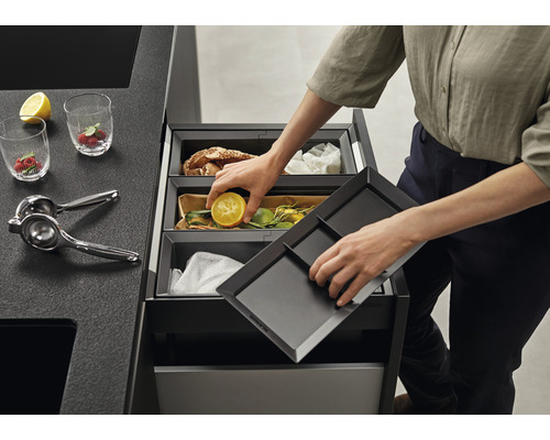 Afvalscheidingssysteem met een persoon die een halve citroen weggooit.