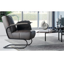 Woonkamer scène met bruine lederen fauteuil, kussen, bijzettafel en decoratie