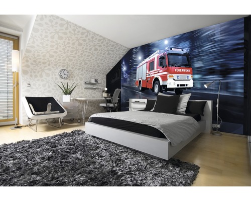 Lichte slaapkamer met fotobehang van een brandweerwagen, bed, bureau en tapijt