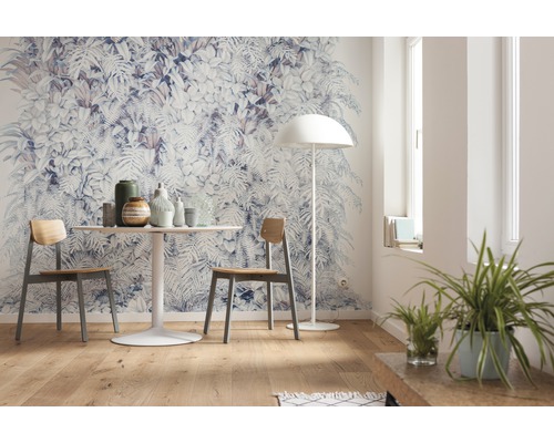 Woonkamer met fotobehang met plantenmotieven, eettafel en stoelen.