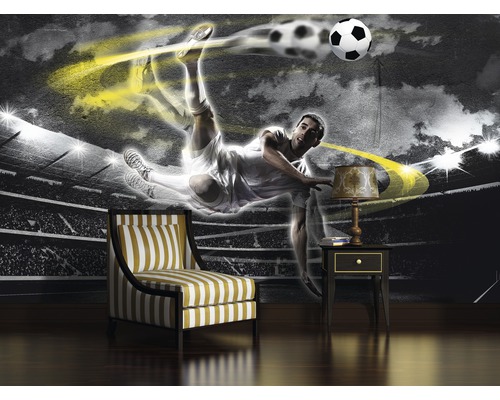 Wanddecoratie met voetbalmotief, fauteuil en nachtkastje in een kamer.