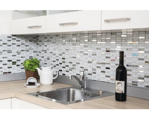 Spoelbak met kraan, mozaïektegels, keukengerei en wijnfles