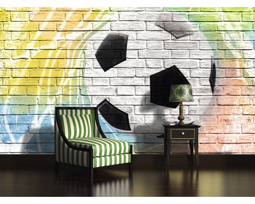 Woonkamer met fauteuil, bijzettafel en een muur met voetbalmotief