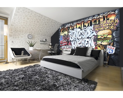 Moderne slaapkamer met graffitimuur, bed, vloerkleed en bureau