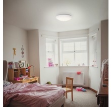 Kamer met bed, bureau, stoel, radiator en plafondlamp