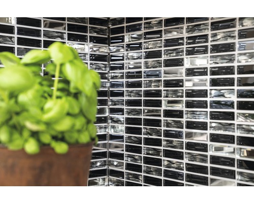 Wandtegels met mozaïekpatroon en plant in pot