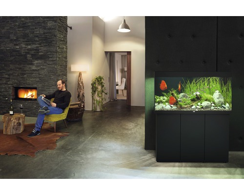 Woonkamer met aquarium, open haard en lezende man