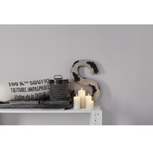 Decoratief stilleven met kussen, blik, kaarsen en letter op een plank