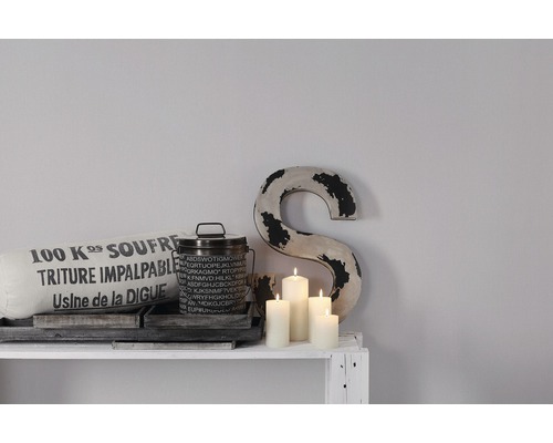 Decoratief stilleven met kussen, blik, kaarsen en letter op een plank