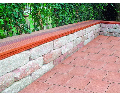 Tuinmuur van steen met houten afdekking en straatstenen