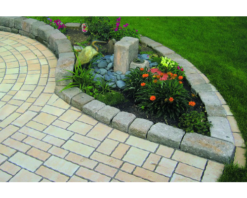 Tuin met stenen pad en bloembed met stenen rand