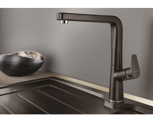 Keukenkraan naast een gootsteen en een kom