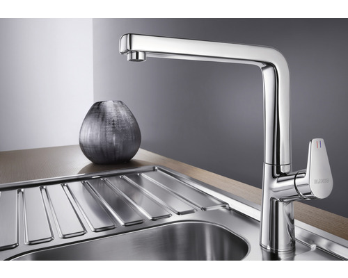 Metalen keukenkraan naast gootsteen