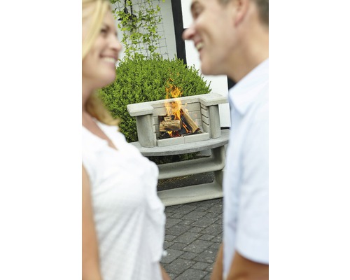 Betonnen buitenhaard met brandend hout en twee personen