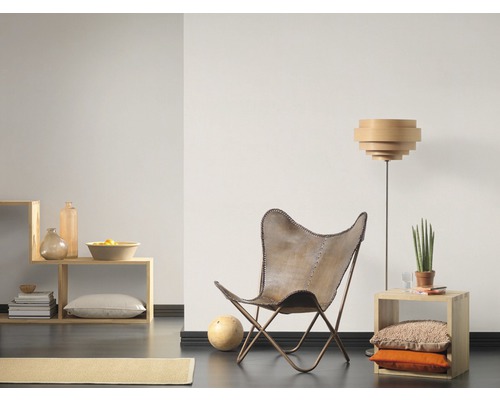 Woonkamer met stoel, staande lamp en houten plank