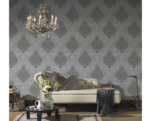 Decoratieve kamer met een bank voor een patroonbehang en een vintage sfeer.