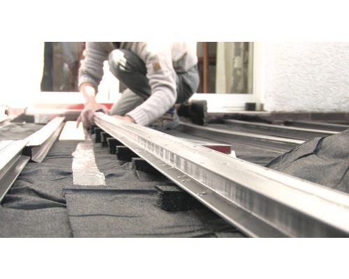 Persoon monteert terrasplanken op een onderconstructie.