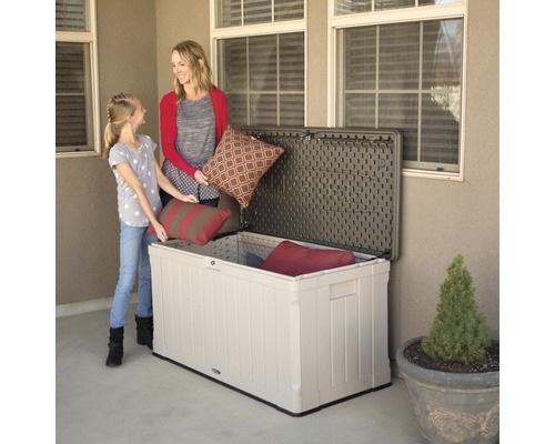 Scene met moeder en dochter die kussens in een opbergbox voor buiten plaatsen