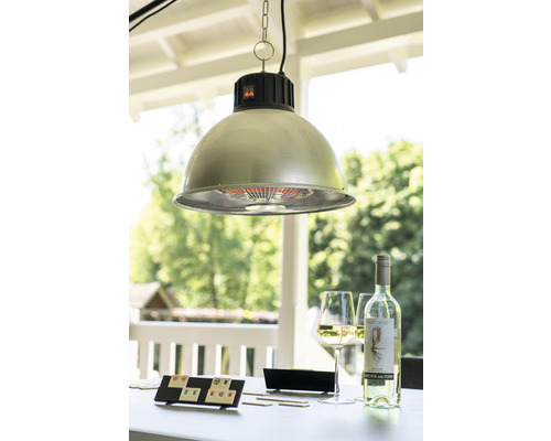 Een buitenscène met een hanglamp, een spel, een fles wijn en glazen op een tafel