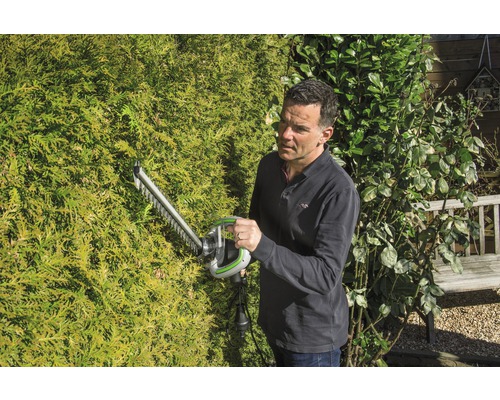 Man snoeit haag met een heggenschaar