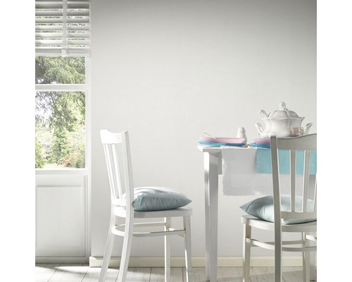 Lichte kamer met witte meubels, tafel en stoelen in scène gezet.