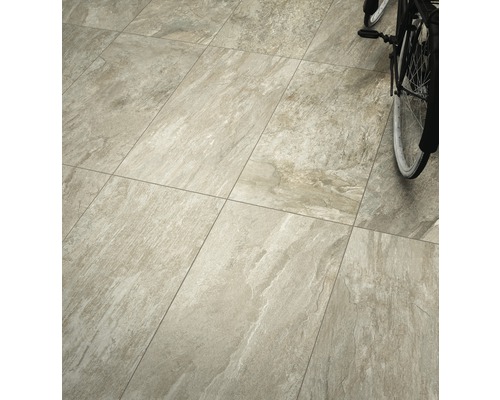 Gelegde vloertegels met natuursteenlook en fiets