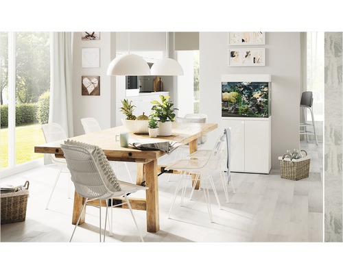 Lichte eetkamer met houten tafel, stoelen en aquarium.