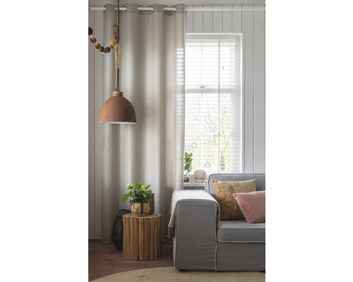 Woonkamer met gordijn, hanglamp, bank en bijzettafel