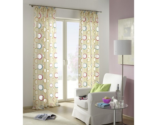 Decoratief gordijn met cirkelpatroon voor een raam in een woonkamer.